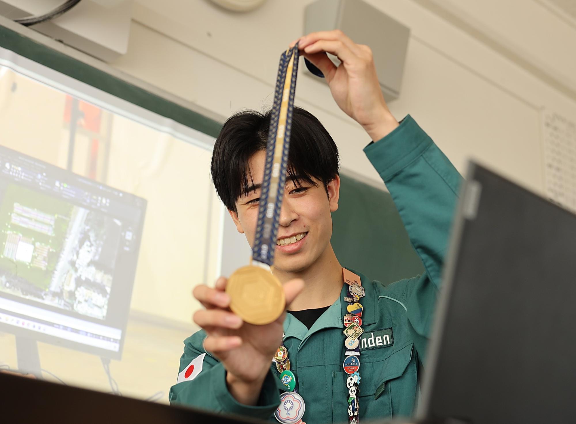 郡安さんがメダルを見せている様子